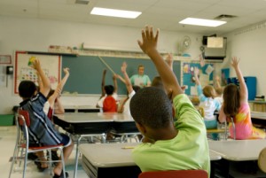 classroom with students raising hands